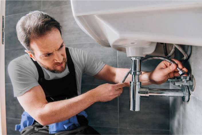 Professional plumber working on residential plumbing